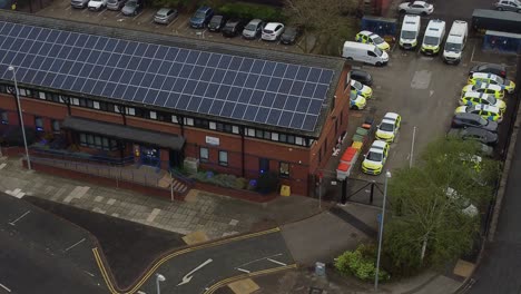 Widnes-town-police-station-with-solar-panel-renewable-energy-rooftop-in-Cheshire-townscape-aerial-descending-tilt-view