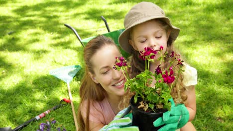 Linda-Niña-Sosteniendo-Una-Maceta-De-Flores-Con-Su-Madre