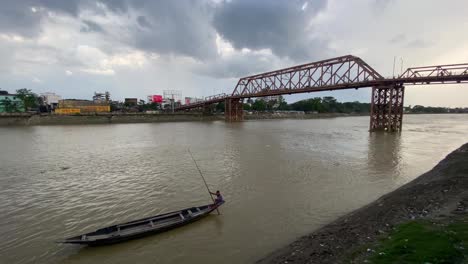 truss-bridge,-wooden-boat,-boatman