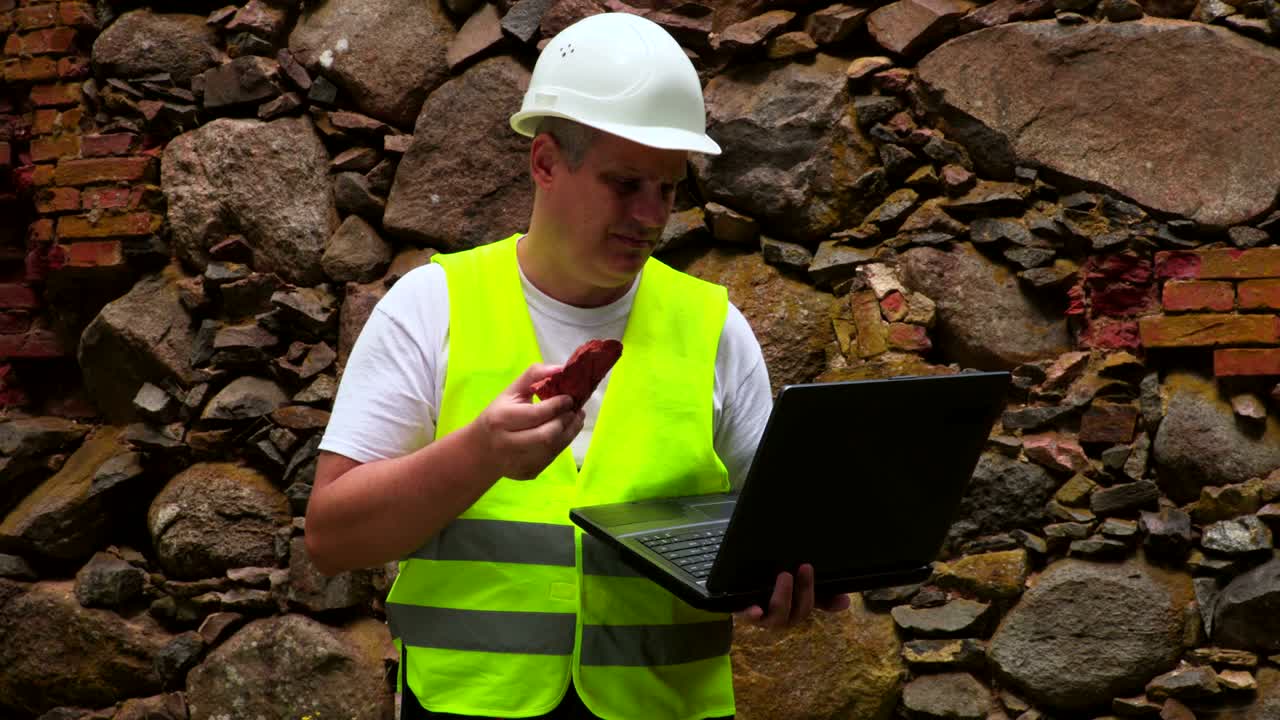 ingeniero con una muestra de la pared de ladrillo vieja