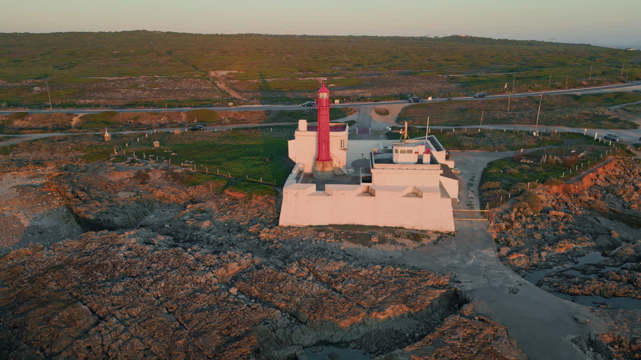 Evening scenery lighthouse standing rocky coast aerial view. Beautiful beacon