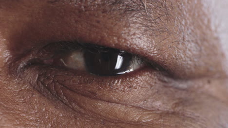 close up senior black man eye looking happy at camera healthy eyesight