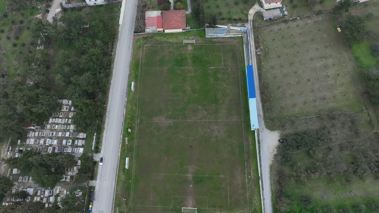 Soccer field next to a graveyard, aerial view of rural sports ground and surroundings