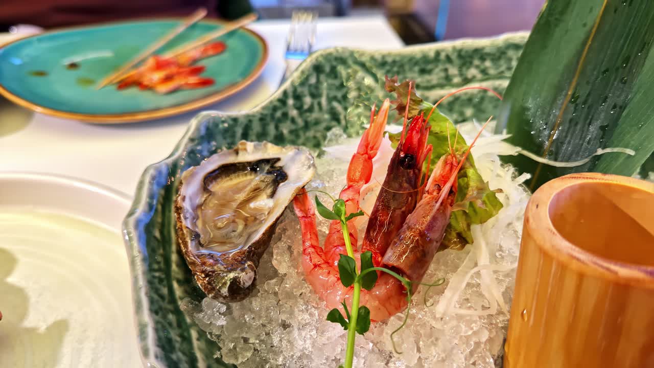 Gourmet seafood dish sashimi platter served on a bed of crushed ice in an ornate green bowl