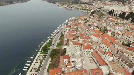 Flying-over-the-city-of-Sibenik,-panoramic-view-of-the-old-town-center-and-coast