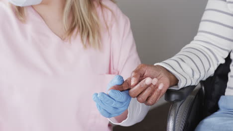 Caucasian-female-nurse-in-face-mask-checking-sugar-of-senior-african-american-woman,-slow-motion