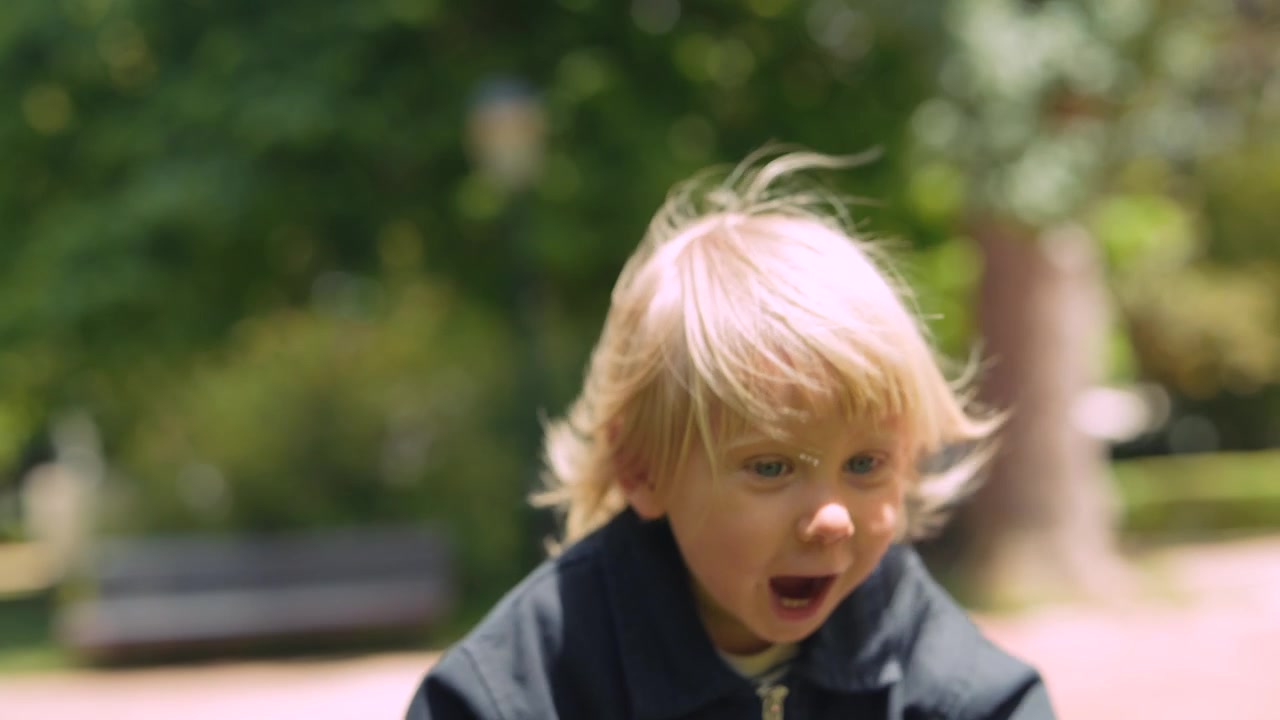 Adorable Blonde Child Looking Around in a Sunny Park
