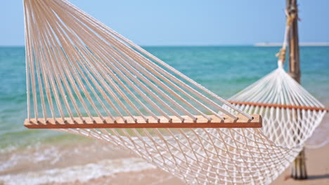 Leere-Hängematte-Am-Tropischen-Strand-Mit-Verschwommenem-Blauem-Meerblickhintergrund