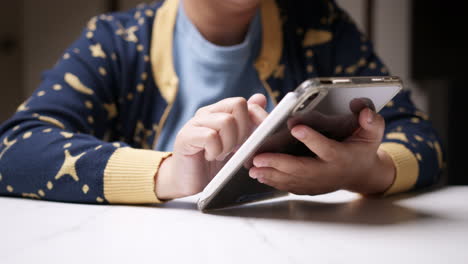 Holding-a-tablet-with-her-left-hand-and-using-the-other-hand-to-browse-the-internet-to-look-for-some-information-and-to-check-her-social-media-status