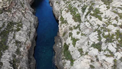 Aerial-view-of-gorge-sea-valley-and-high-cliffs-in-Ghasri,-Gozo,-Malta-island-on-summer-day