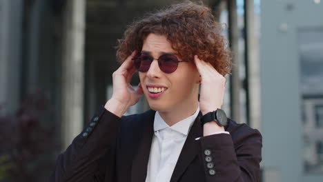 caucasian businessman in formal suit feels a headache migraine on the street near an office building