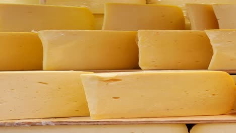 close up of yellow cheese blocks in a market