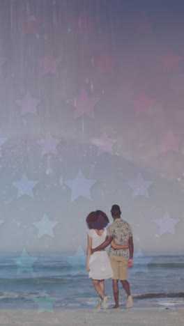 animation of stars over back of african american couple walking on beach