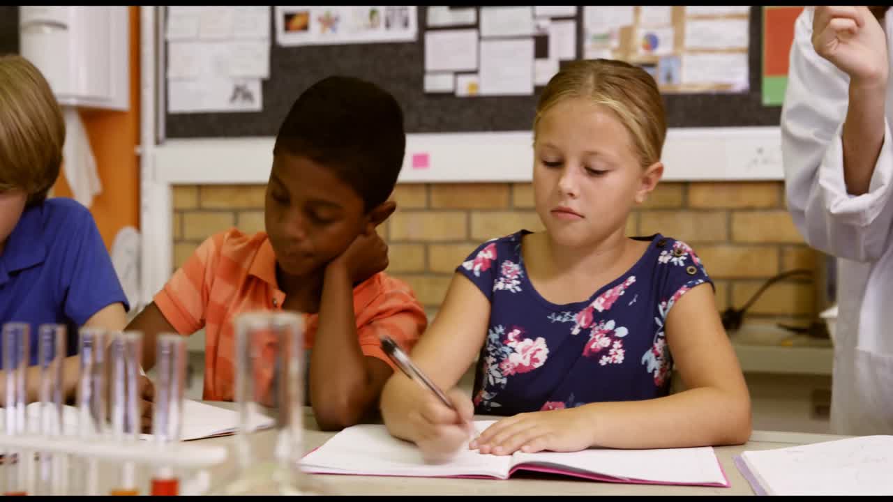Teacher assisting school kids with molecule model in classroom