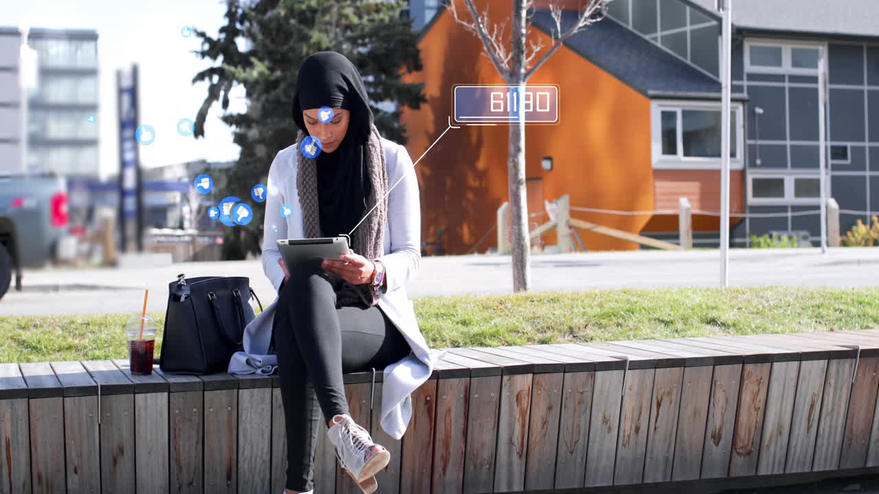 Animation of a biracial woman wearing hijab using tablet computer with floating like symbols