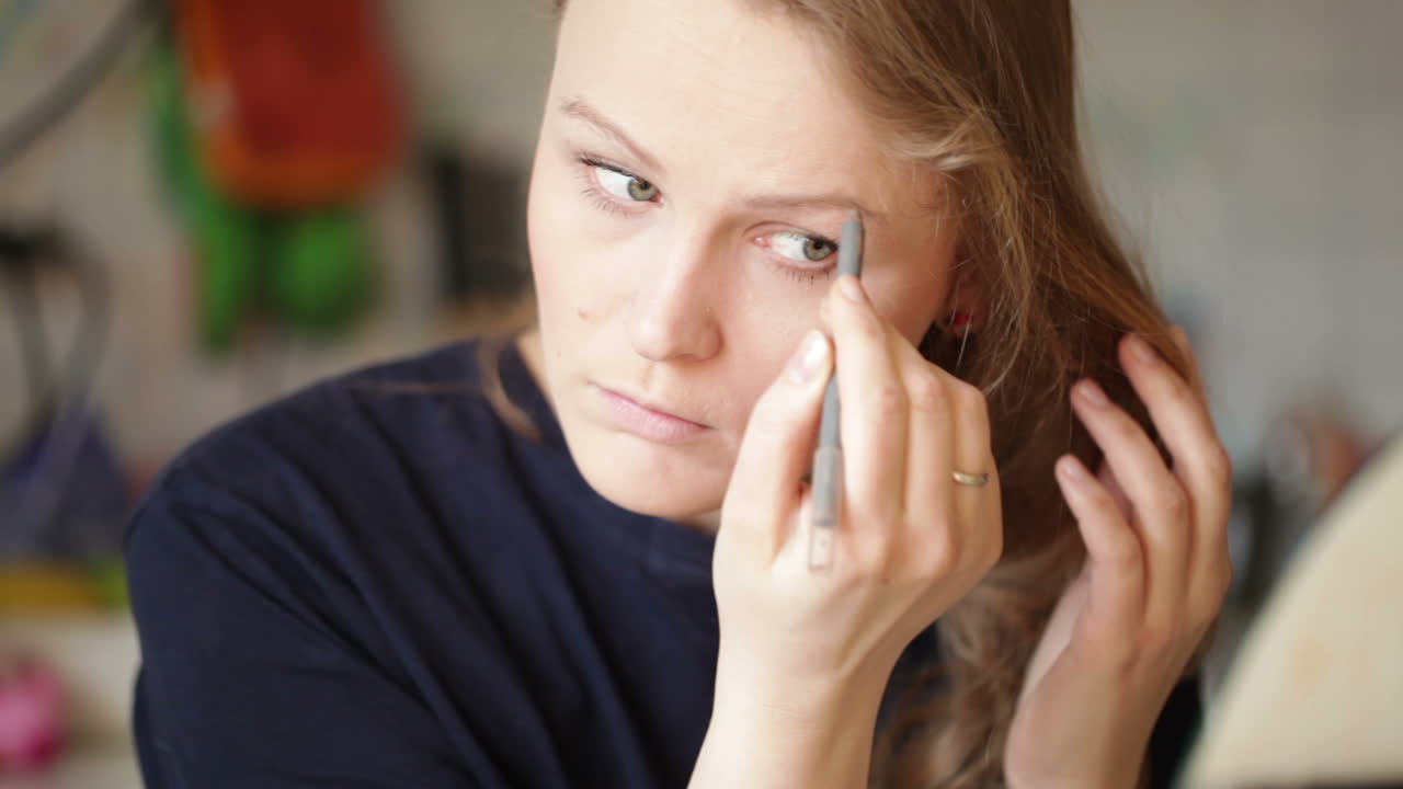 Young woman shaping her eyebrows