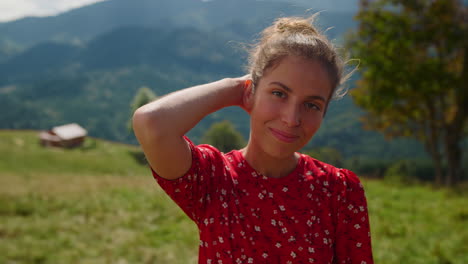 attraktive frau sucht kamera auf grüner wiese. porträt mädchen lächelnd sonniger tag