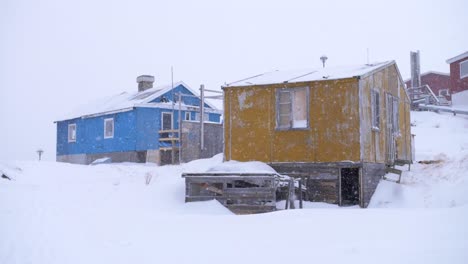 video en cámara lenta de casas amarillas y azules en una tormenta de nieve en ilulissat, groenlandia