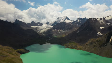 Slow-aerial-drone-shot-of-the-mountain-range-circling-the-Ala-Kol-lake-in-Kyrgyzstan