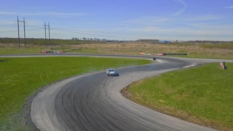 drifting race car on a track going into a s turn, aerial top down shot