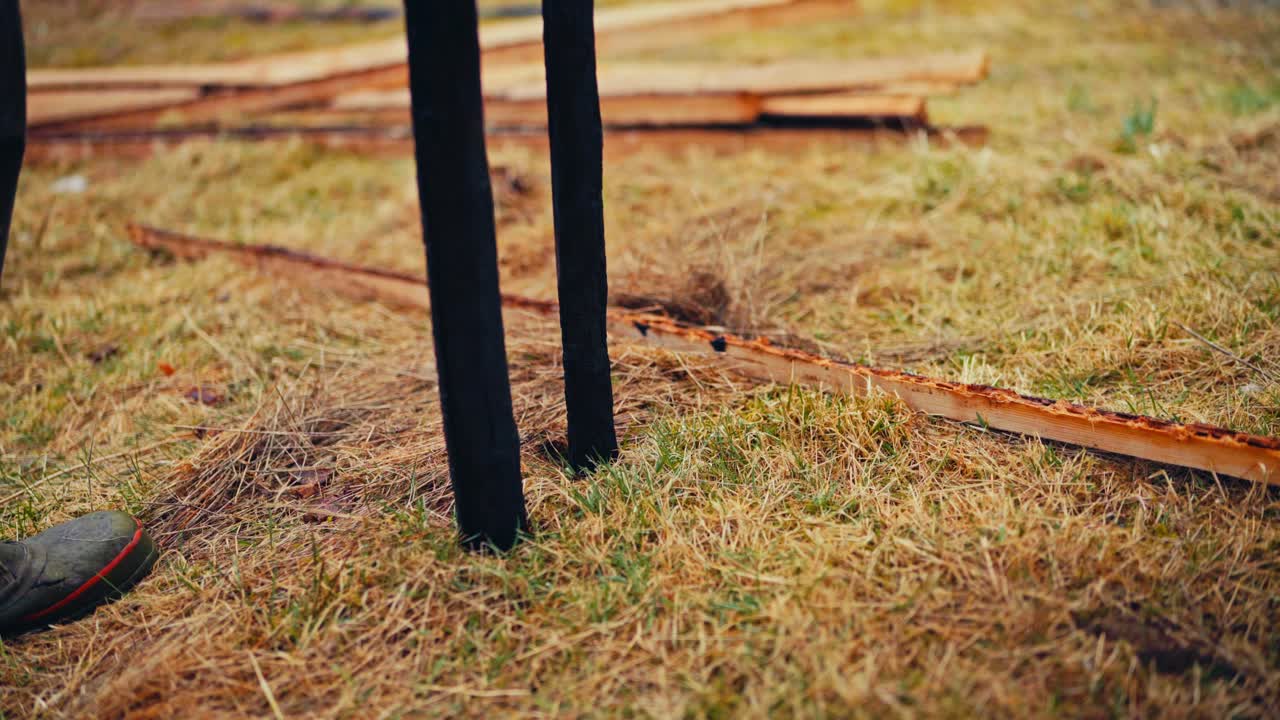 Putting Charred Wooden Poles While Building Traditional Fence - Close Up