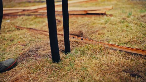 putting charred wooden poles while building traditional fence - close up