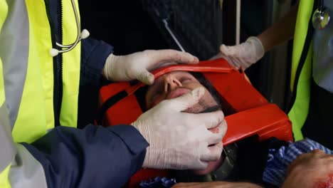 emergency medical technicians examining the eyes of their wounded person