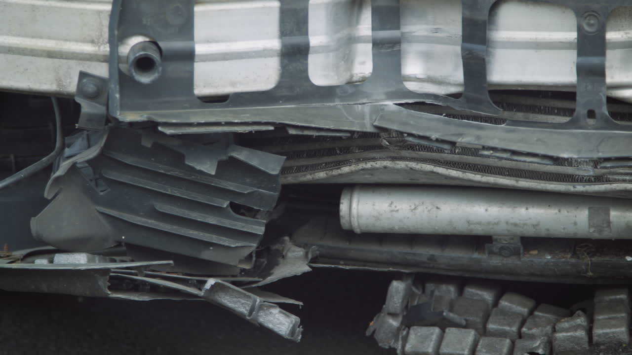 detalle de un coche dañado en un accidente automovilístico estacionado en un taller de reparación de garaje