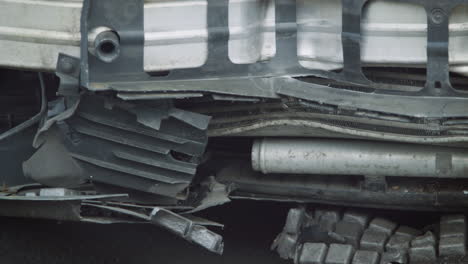 detail of car damaged in motor vehicle accident parked in garage repair shop