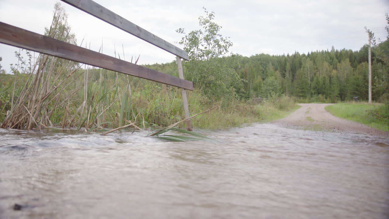 River overflowing at gravel road due to rainwater runoff, climate change