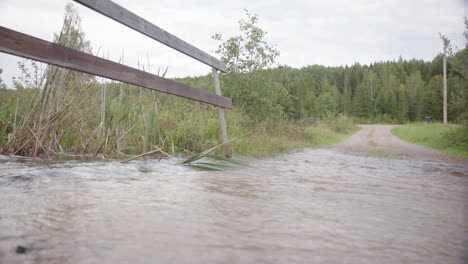 Río-Desbordado-En-Camino-De-Grava-Debido-A-La-Escorrentía-De-Agua-De-Lluvia,-El-Cambio-Climático