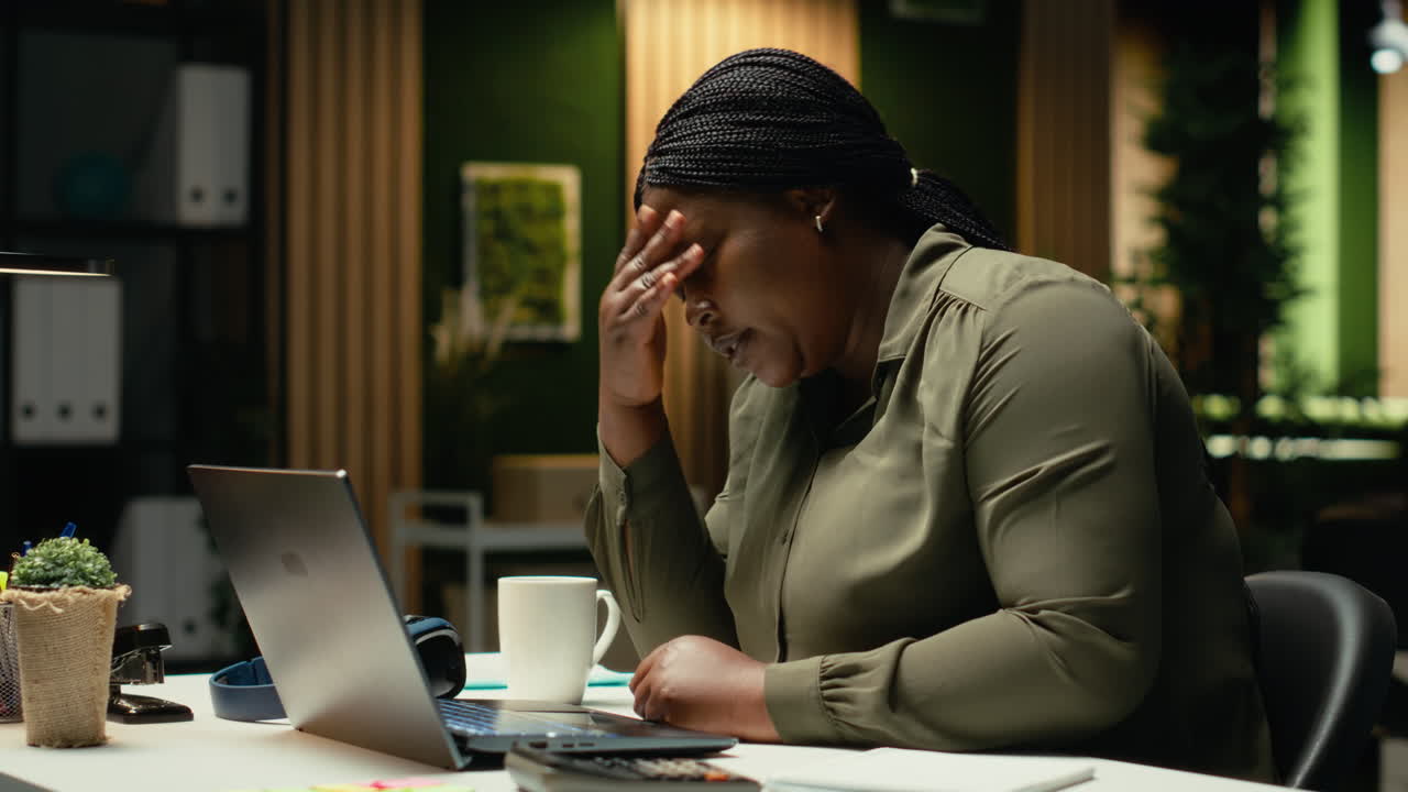 Fatigued entrepreneur sighing and struggling to stay awake late at night