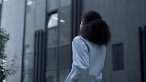 Businesswoman-posing-outside-office-building-alone.-Smiling-employee-portrait.