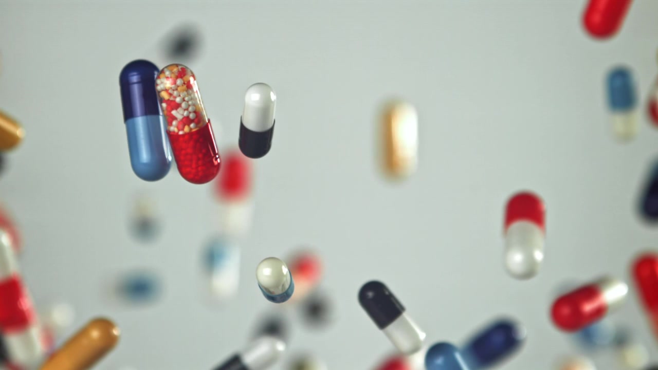 Colorful Pills and Capsules Falling in Slow Motion