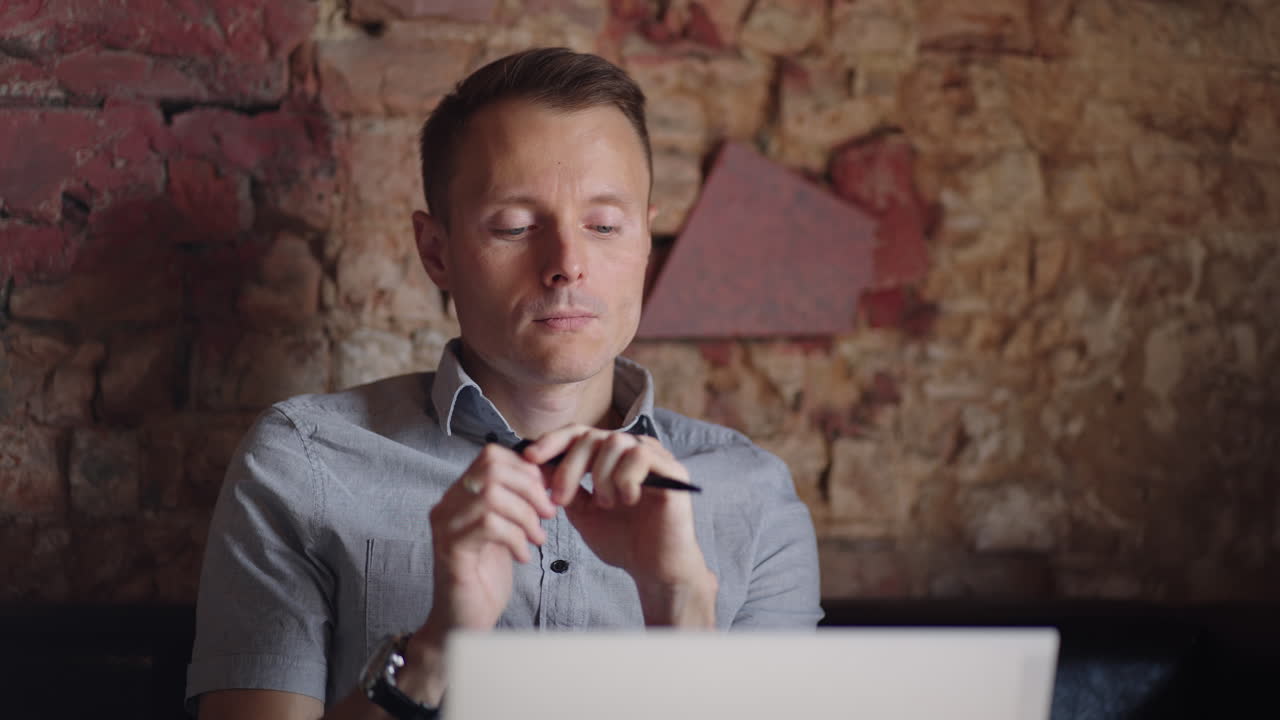 el hombre mira su computadora portátil y piensa. tomar decisiones en educación y negocios. pensar e inventar mientras está sentado con una computadora portátil