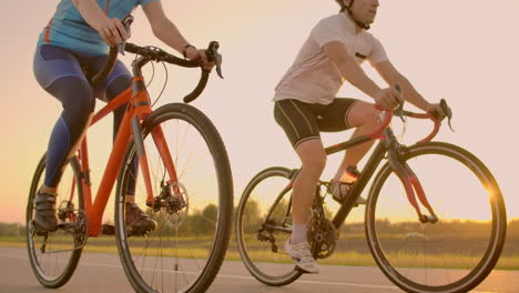 Empty-Space.-Sporty-friends-on-bicycle-on-sunset.-Couple-cyclist-go-along-coast.-Sport-in-Nature-background.-Group-of-people-two-road-biker-in-sunset.