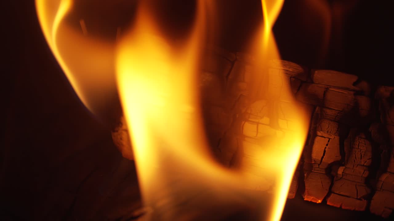 Un tronco ardiendo dentro de un quemador de leña