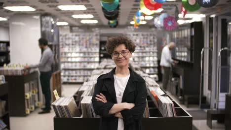 happy female record shop owner posing and smiling for camera