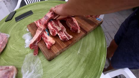 video en cámara lenta de un hombre blanco cortando la carne cruda antes de ponerla en la parrilla.