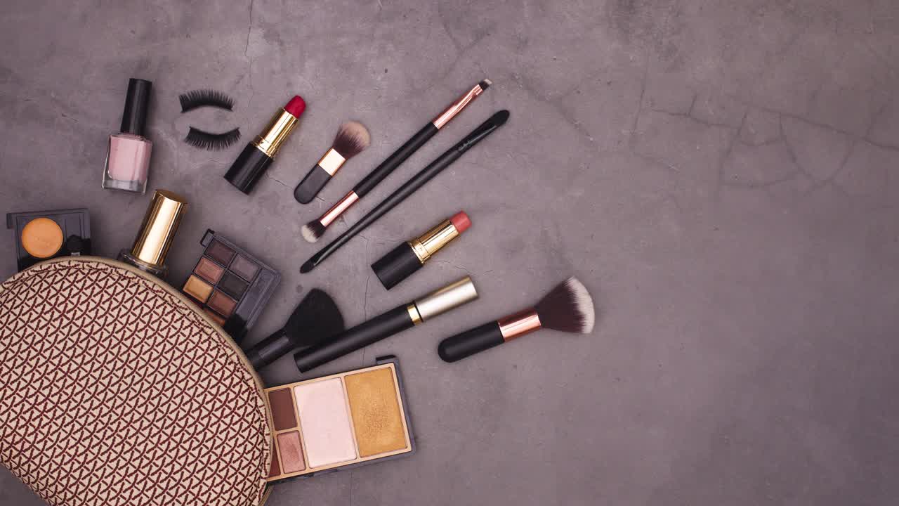 Lipsticks, brushes, eye shadows, perfume appear from make up kit. Stop motion