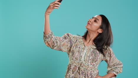 cheerful woman using smartphone to take selfies