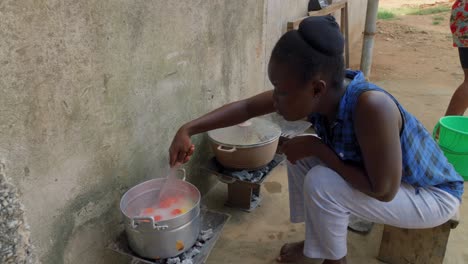 young black female woman preparing traditional ghanese fufu food in outdoor kitchen