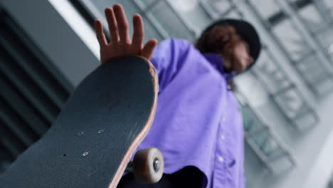 unknown hipster twirling longboard outside. man hand playing with skate outdoor.