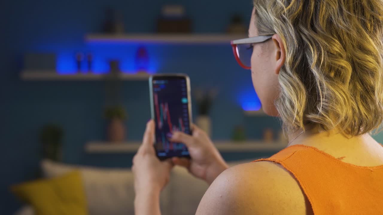 mujer examinando velas gráficas en el mercado de valores.