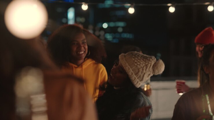 glückliche gruppe von freunden tanzen zu lebhafter dachparty-musik genießen wochenendfeier in der städtischen stadt in der nacht