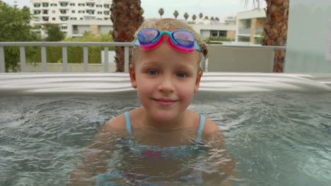 niña de cinco años disfrutando de una bañera de agua caliente al aire libre