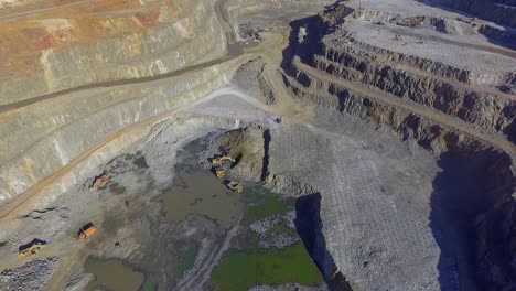 Heavy machinery working in te riotinto open pit copper mine aerial shot