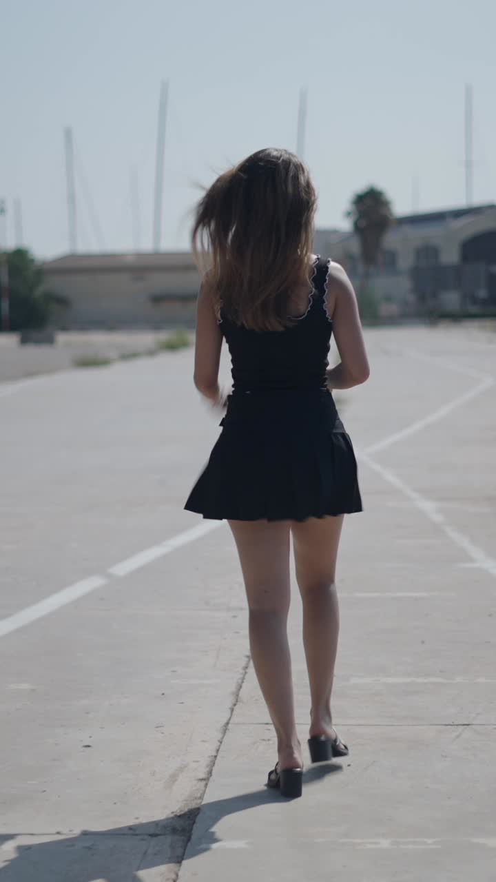 黒いドレスを着た女性が屋外を走っている