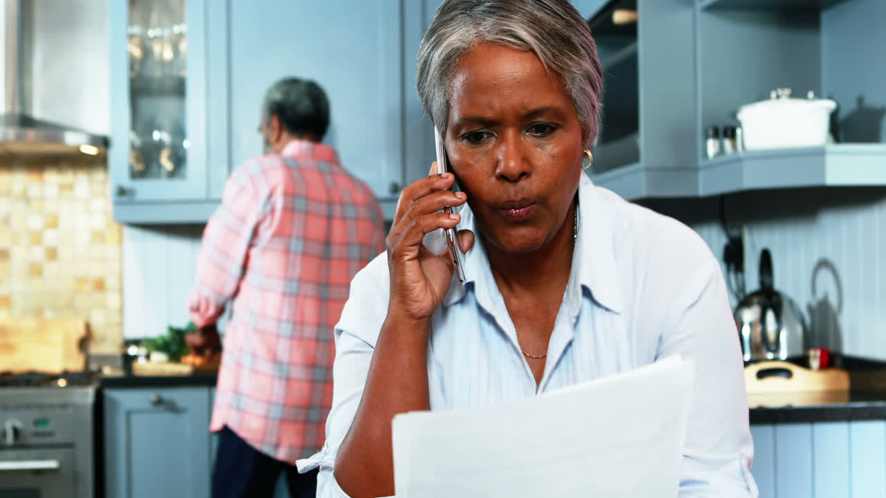 Senior woman talking on mobile phone in kitchen
