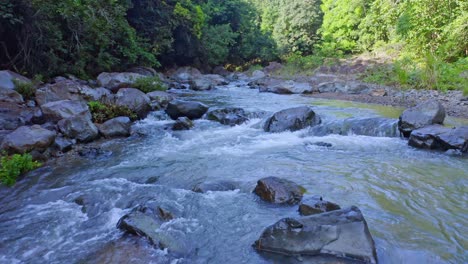 stones in river water - summer nature scene at rio higuero, dominican republic - aerial drone shot